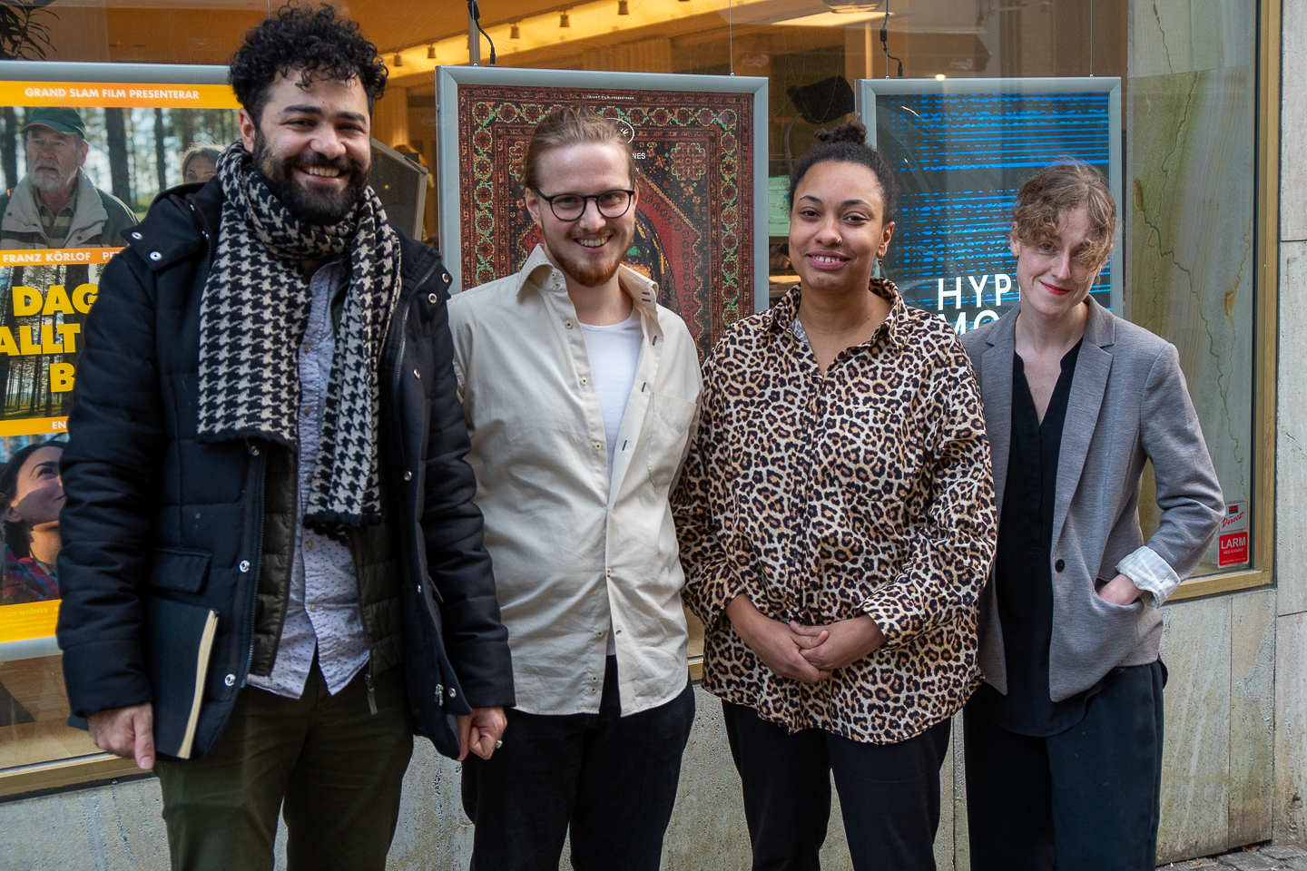 Fyra personer framför skyltfönster med filmplancher