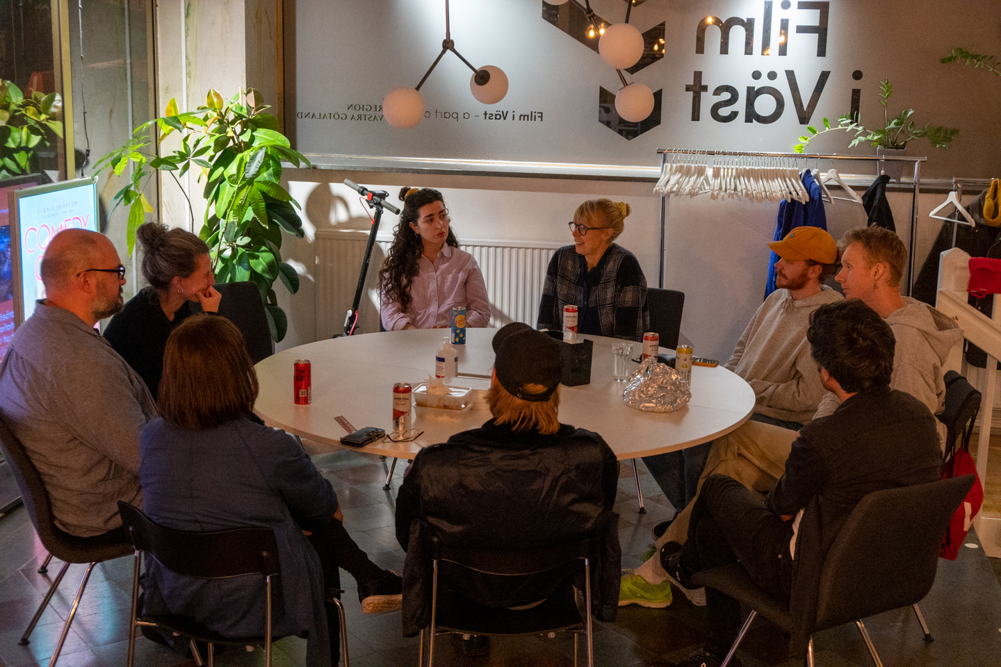 Deltagare runt ett matbord med Film i Västs logga i bakgrunden
