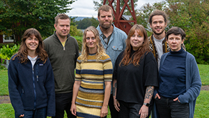 7 personer framför klockstapel