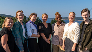 sju filmare framför utsikt över havsvik