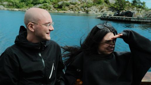 Man och kvinna ser glada ut när de åker på ett fartyg.