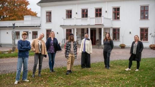 grupp människor framför herrgård.