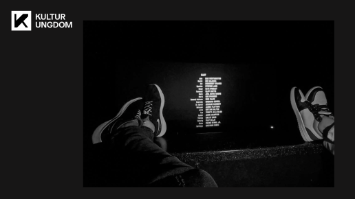 Fötter på biografens stolsryggar och eftertexter i bakgrunden