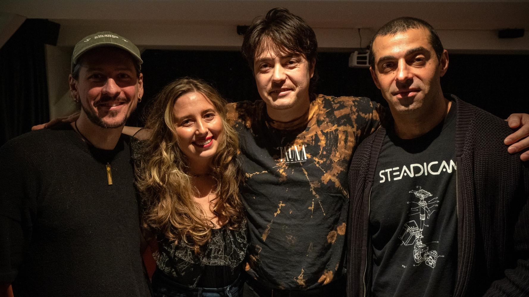 Fyra personer ser in i kameran och ler