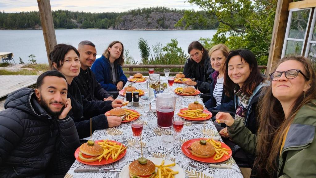 Åtta personer runt ett bord med serverade hamburgare