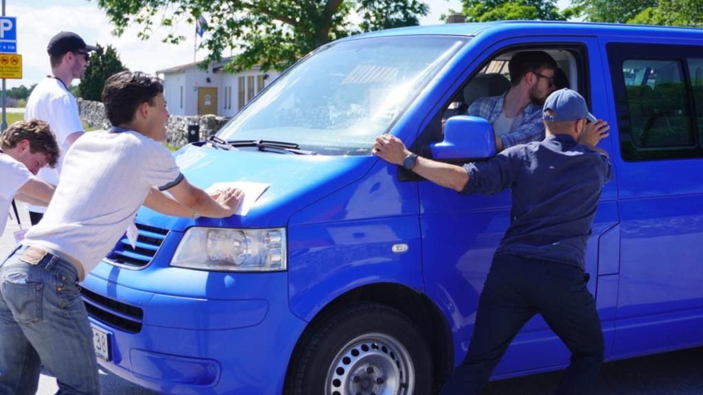 Ett gäng killar puttar en minibuss.